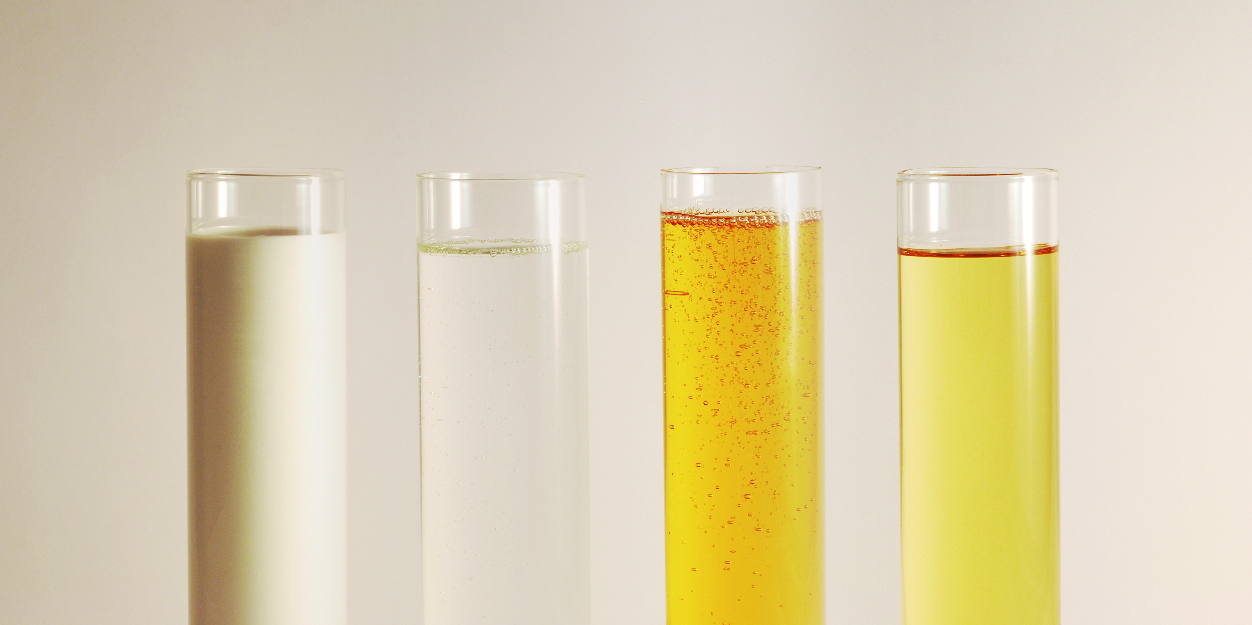 Una varietà di formulazioni chimiche liquide in provette da laboratorio, che riflettono l'ampia competenza e il variegato portafoglio prodotti di SAWEX SA per molteplici applicazioni industriali